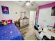 Bright bedroom with a ceiling fan, purple accent wall, and matching wood-look flooring at 7204 Cranswick Pl, Charlotte, NC 28227