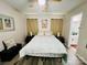 Well-lit bedroom with a ceiling fan, wood-look flooring, and a view into the bathroom at 7204 Cranswick Pl, Charlotte, NC 28227