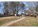Large backyard featuring a stone walkway, storage shed, and fire pit, providing ample outdoor space at 7435 Trotter Rd, Charlotte, NC 28216