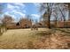 Expansive backyard featuring a fire pit and mature trees, ideal for outdoor entertaining and relaxation at 7435 Trotter Rd, Charlotte, NC 28216