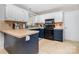 Kitchen features white cabinetry, dark hardware, and stylish backsplash and breakfast bar at 7435 Trotter Rd, Charlotte, NC 28216