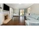 Open-concept living room with hardwood floors, a fireplace, and a sliding glass door leading to the backyard at 7435 Trotter Rd, Charlotte, NC 28216
