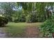 Spacious backyard with green lawn, trees, and outdoor seating area at 8731 Sheltonham Way, Charlotte, NC 28216