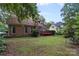 Brick home's backyard featuring green lawn, and a small wooden deck at 8731 Sheltonham Way, Charlotte, NC 28216