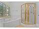 Bathroom with a glass shower and a tub under a window with blinds at 8731 Sheltonham Way, Charlotte, NC 28216