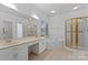 Bright bathroom featuring double sinks, a tub, and a glass shower at 8731 Sheltonham Way, Charlotte, NC 28216