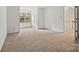 Bedroom with carpet, a window, and a door leading to the upper-level hallway at 8731 Sheltonham Way, Charlotte, NC 28216