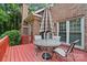 Red painted wooden deck with a patio table and four chairs with brick exterior in background at 8731 Sheltonham Way, Charlotte, NC 28216