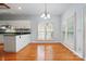 Bright dining area featuring wood floors, white cabinets, and a view of the backyard at 8731 Sheltonham Way, Charlotte, NC 28216