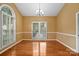 Bright dining room with hard wood floors, traditional chandelier and large windows at 8731 Sheltonham Way, Charlotte, NC 28216