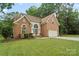 Charming brick home featuring an attached two-car garage and well-manicured lawn at 8731 Sheltonham Way, Charlotte, NC 28216