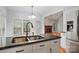 Island kitchen with double sinks, granite counter, and stainless steel fridge at 8731 Sheltonham Way, Charlotte, NC 28216