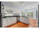 Bright kitchen features white cabinets, stainless steel appliances, and hardwood floors at 8731 Sheltonham Way, Charlotte, NC 28216