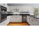 White kitchen with stainless steel appliances and dark granite countertop at 8731 Sheltonham Way, Charlotte, NC 28216