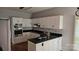 Modern kitchen with white cabinets, dark countertops, and stainless steel built in microwave and oven at 8731 Sheltonham Way, Charlotte, NC 28216
