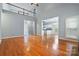 Open-concept living space with hardwood floors, high ceilings, and a view of the kitchen and second floor at 8731 Sheltonham Way, Charlotte, NC 28216