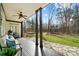 Inviting covered back porch with ceiling fan and outdoor seating overlooks a spacious, well-manicured yard at 10000 Blossom Dr, Concord, NC 28025