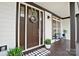 A cozy front porch with a decorated door, black and white mat, and comfortable seating at 10000 Blossom Dr, Concord, NC 28025