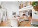 Bright, open-concept living room with hardwood floors, comfortable seating, and an open staircase at 10000 Blossom Dr, Concord, NC 28025