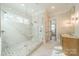 Luxurious bathroom featuring a glass-enclosed shower, marble tiling, and modern fixtures at 102 Pecan Cove Ln, Weddington, NC 28104
