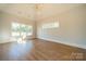 Light-filled bedroom with hardwood floors and large windows showcasing the outdoor view at 102 Pecan Cove Ln, Weddington, NC 28104