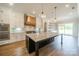 Bright modern kitchen with white cabinets, marble backsplash, and large island with seating at 102 Pecan Cove Ln, Weddington, NC 28104