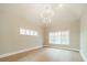 Bright living room with light hardwood floors, crisp white trim, and a modern chandelier at 102 Pecan Cove Ln, Weddington, NC 28104