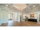 Bright open-plan living and kitchen space with coffered ceiling, hardwood floors, and modern chandelier at 102 Pecan Cove Ln, Weddington, NC 28104