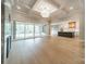 Bright living room with large sliding doors, a cozy fireplace, and a view of the kitchen area, creating a comfortable living space at 102 Pecan Cove Ln, Weddington, NC 28104