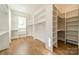 Spacious walk-in closet with custom shelving, hanging rods, and natural light at 102 Pecan Cove Ln, Weddington, NC 28104