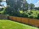 Backyard view featuring a wooden fence and lush vegetation at 1021 Joselynn Dr, Gastonia, NC 28054