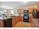 Well-lit kitchen with wood cabinets, black appliances, and ample counter space at 1021 Joselynn Dr, Gastonia, NC 28054