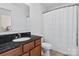 Bathroom with wood cabinets, granite countertop, toilet, and tub-shower with curtain at 1065 Ellis Pond Dr, Rock Hill, SC 29730