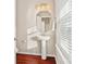 Stylish half bathroom with pedestal sink, decorative mirror, and natural light from window at 1065 Ellis Pond Dr, Rock Hill, SC 29730