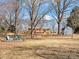 Expansive backyard view with fire pit seating area and storage shed adjacent to the home at 10720 Forest Dr, Matthews, NC 28105