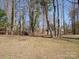 Large backyard with mature trees offers privacy and ample space for outdoor activities and relaxation at 10720 Forest Dr, Matthews, NC 28105