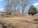 Expansive backyard with mature trees and a glimpse of the back of the house featuring a deck at 10720 Forest Dr, Matthews, NC 28105