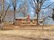 A shot of a backyard showcasing the house with mature trees, a shed, and generous open space at 10720 Forest Dr, Matthews, NC 28105