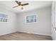 Bright bedroom with wood floors, a modern ceiling fan, and two windows offering plenty of natural light at 10720 Forest Dr, Matthews, NC 28105