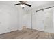 Bright bedroom features hardwood floors, ceiling fan, and ensuite bathroom with sliding barn door at 10720 Forest Dr, Matthews, NC 28105