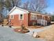 A charming brick home featuring a well-manicured lawn and stone walkway, enhancing its curb appeal and welcoming atmosphere at 10720 Forest Dr, Matthews, NC 28105