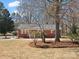 Charming brick home with manicured front yard, showcasing curb appeal and inviting entry with mature trees at 10720 Forest Dr, Matthews, NC 28105
