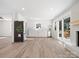 Open kitchen with white cabinets, stainless appliances, brick fireplace, and sliding glass doors to deck at 10720 Forest Dr, Matthews, NC 28105