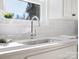 Close up on stainless steel kitchen sink and faucet with white subway tile backsplash at 10720 Forest Dr, Matthews, NC 28105
