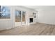 Open living room with a white brick fireplace and sliding glass doors to an outdoor deck at 10720 Forest Dr, Matthews, NC 28105