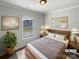 Staged bedroom with natural light, modern decor, and a comfortable queen-sized bed at 11005 Cobb Creek Ct, Charlotte, NC 28277