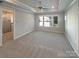 Large primary bedroom featuring a tray ceiling, carpet floors and natural light at 11005 Cobb Creek Ct, Charlotte, NC 28277