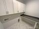 Well-lit laundry room with ample cabinet space and counter, plus stylish tiled floors at 11005 Cobb Creek Ct, Charlotte, NC 28277
