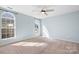 Bright bedroom featuring neutral carpet, ceiling fan, and arched windows at 11132 White Stag Dr, Charlotte, NC 28269