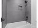 Close up of tile shower over tub with black fixtures and built-in niche in bathroom at 119 Mills Garden Rd, Statesville, NC 28625